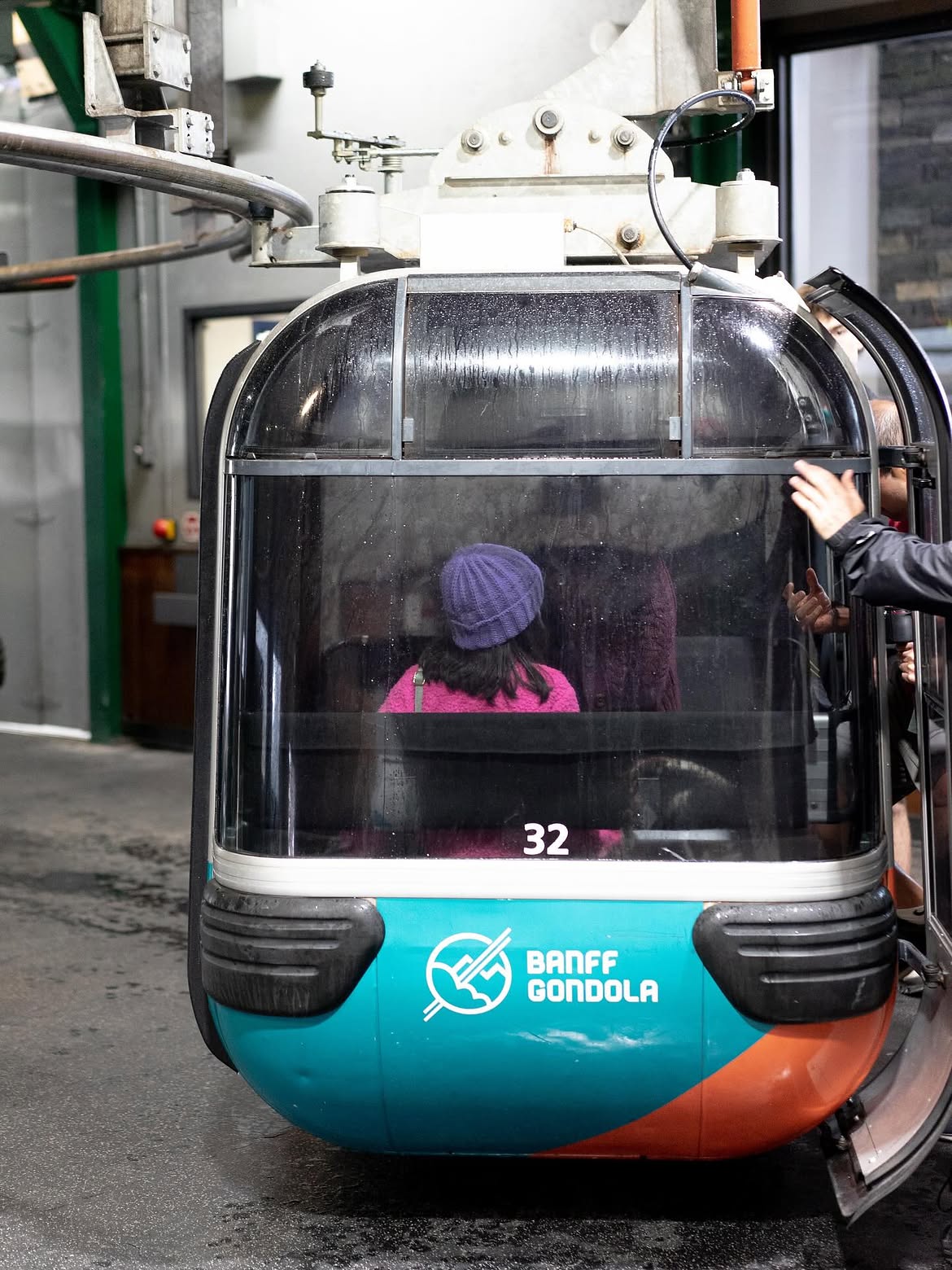 A Banff Gondola cabin at the boarding station with passengers seated inside